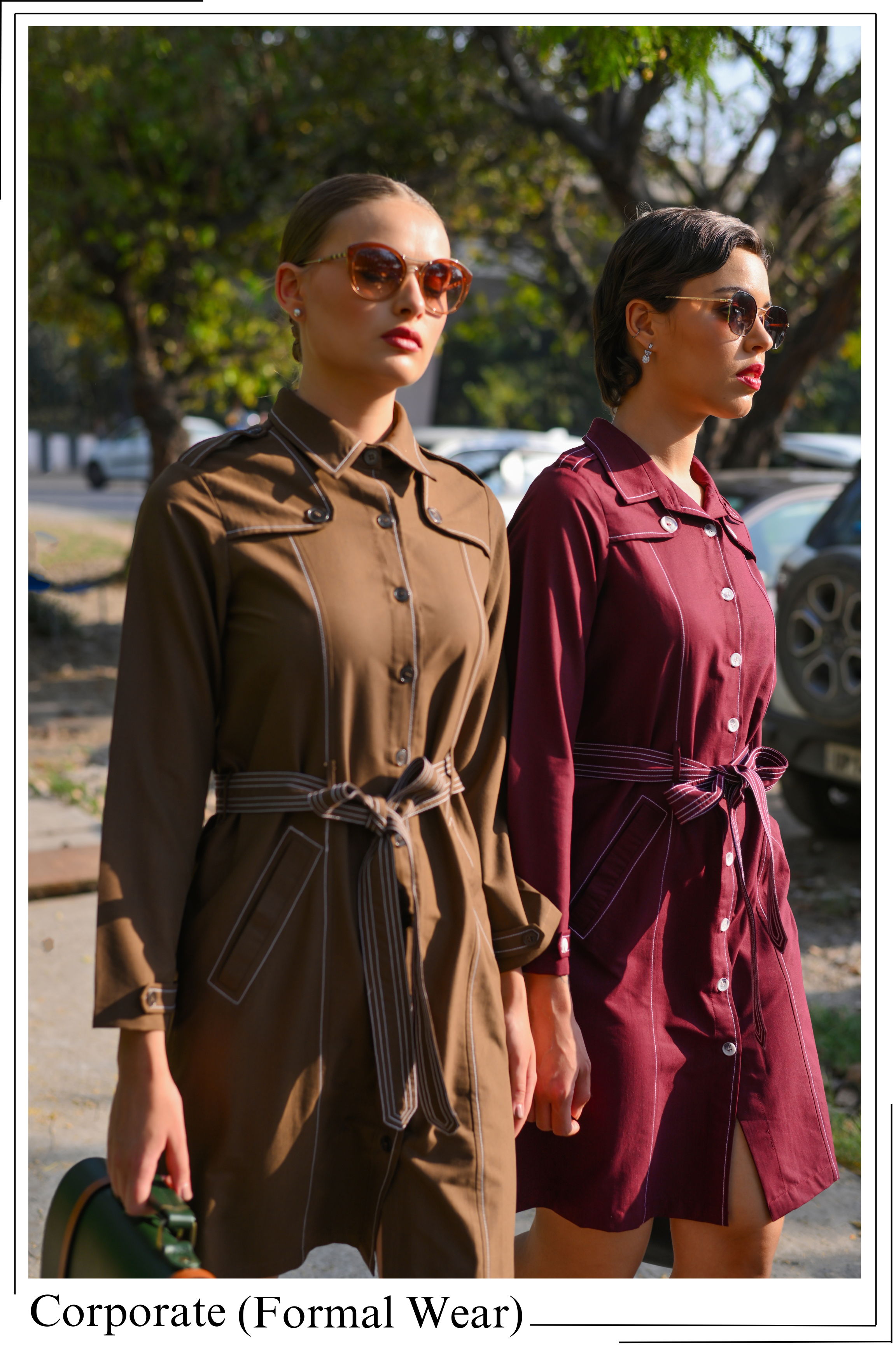 Two women wearing formal wear standing outdoors with trees and cars in the background.